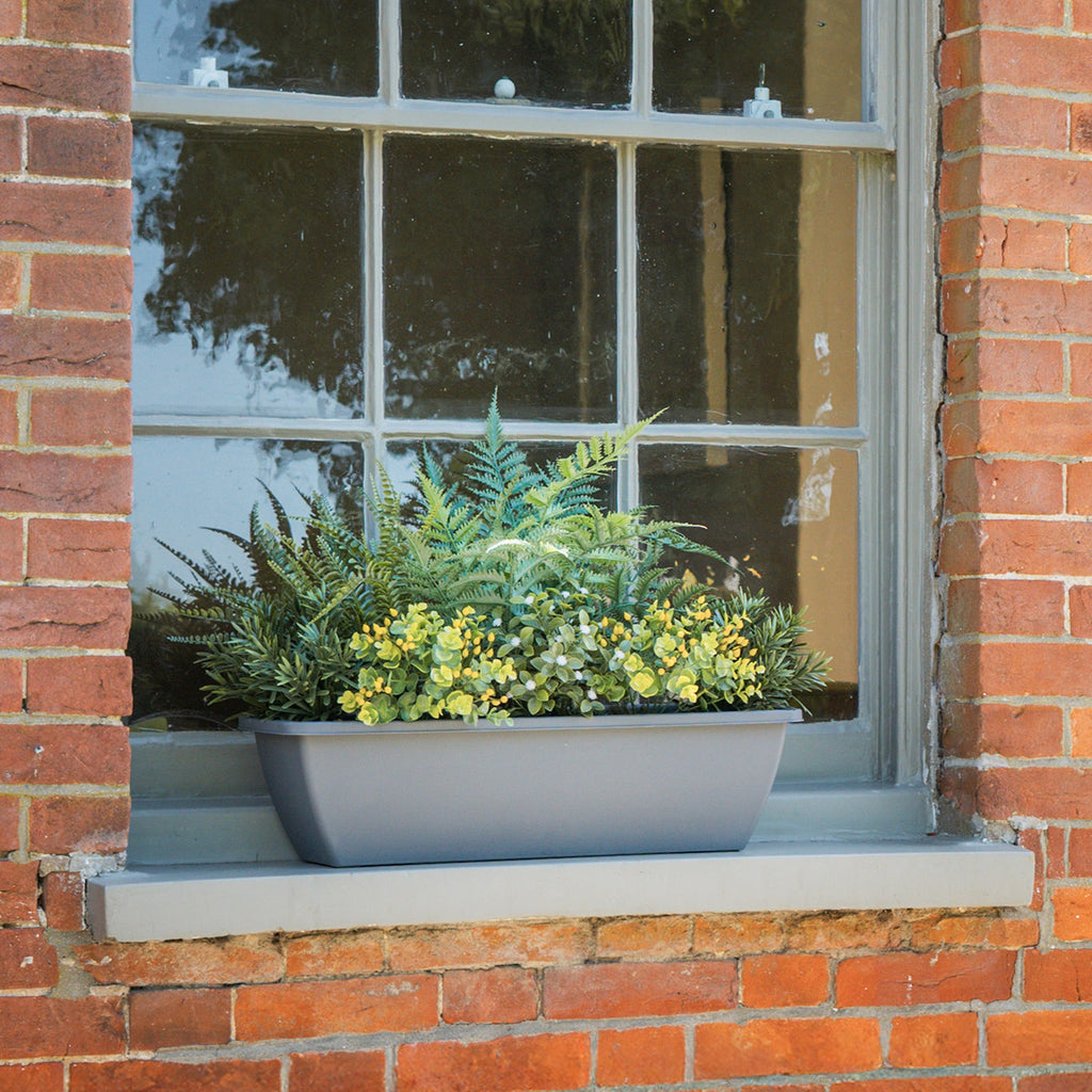 Window box with plants on a brick wall
