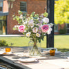 Outdoor table setting with flowers and glasses on a patio