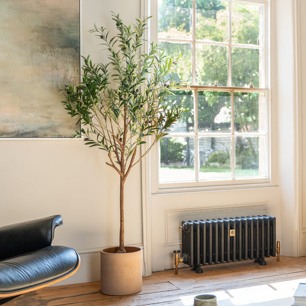 Modern living room with a yellow sofa, black armchair, and a radiator.