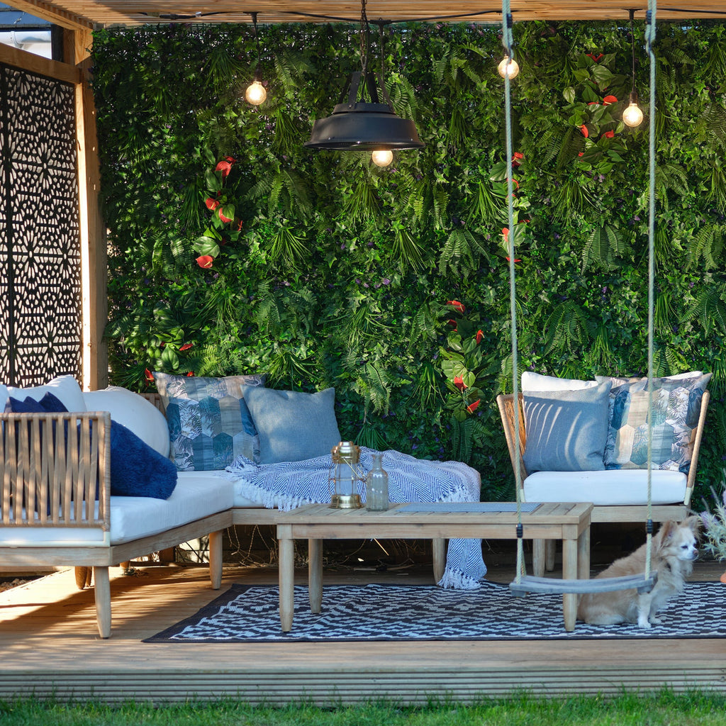 Outdoor patio with wooden furniture, swing, and greenery