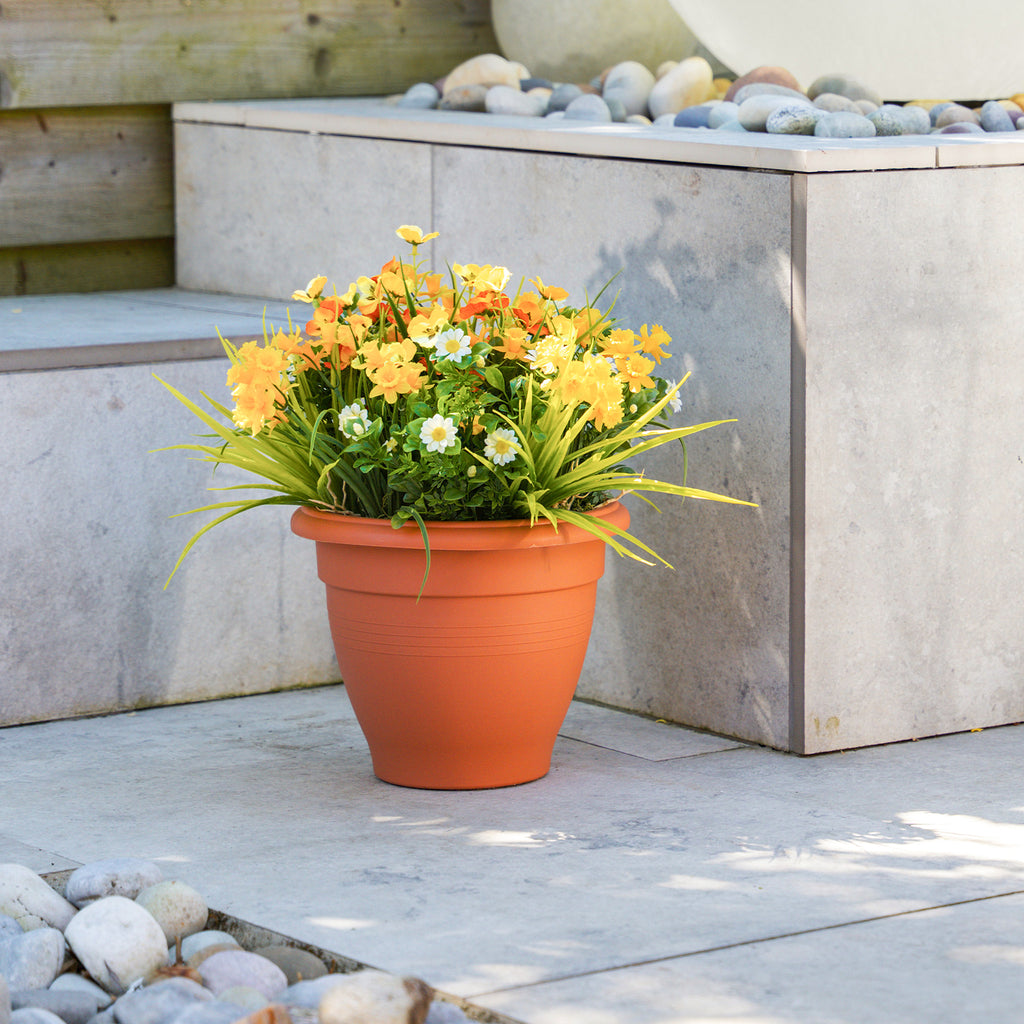 Potted plant with yellow flowers on a stone patio