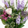 Bouquet of flowers with purple and white flowers, green leaves, and a pink rose.