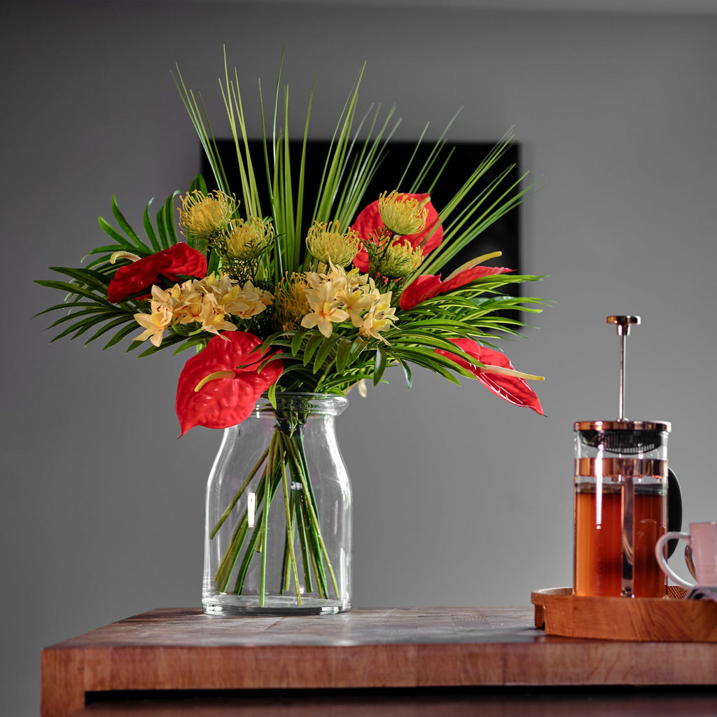 Bouquet of flowers in a clear vase on a wooden table with a blurred background