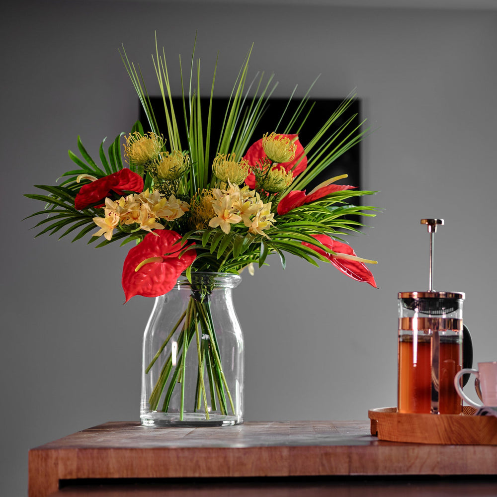 Bouquet of flowers in a clear vase on a wooden table with a blurred background