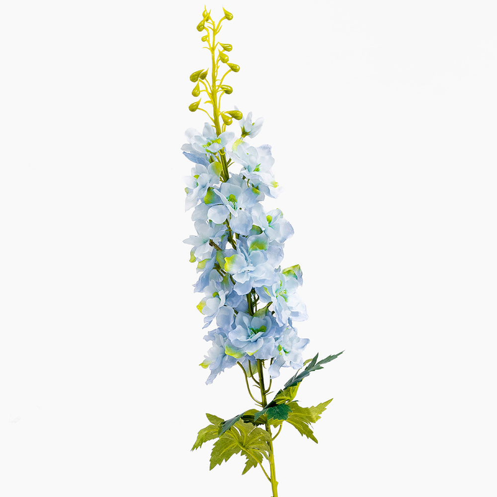 Artificial flower branch with blue flowers and green leaves on a white background