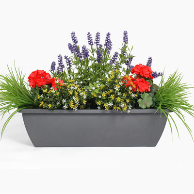 Gray rectangular planter with a variety of colorful flowers on a white background