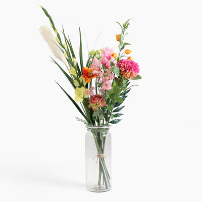 Bouquet of colorful flowers in a clear glass vase on a white background