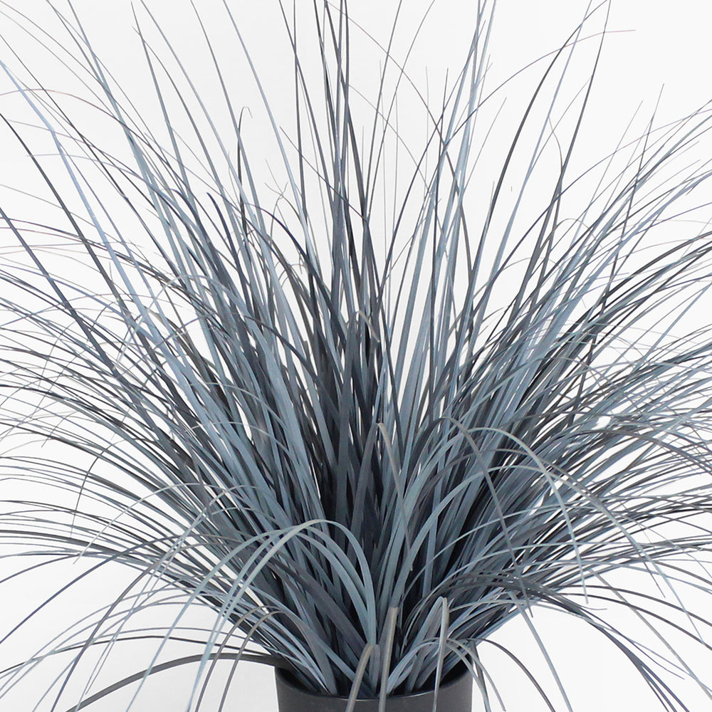 Faux potted plant with long, thin leaves on a white background