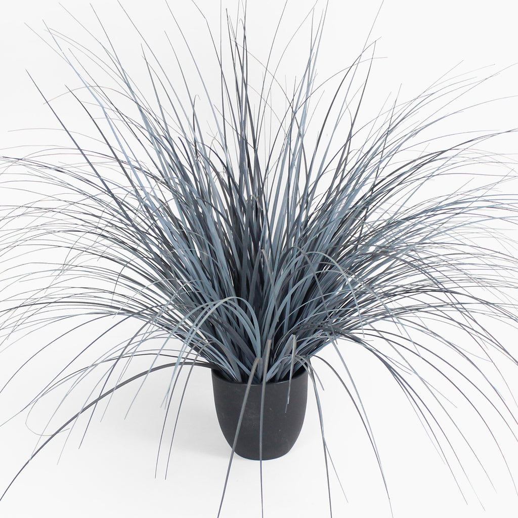 Faux potted plant with long, thin leaves on a white background