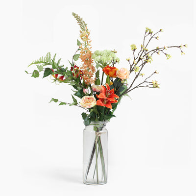 Bouquet of flowers in a clear glass vase on a white background
