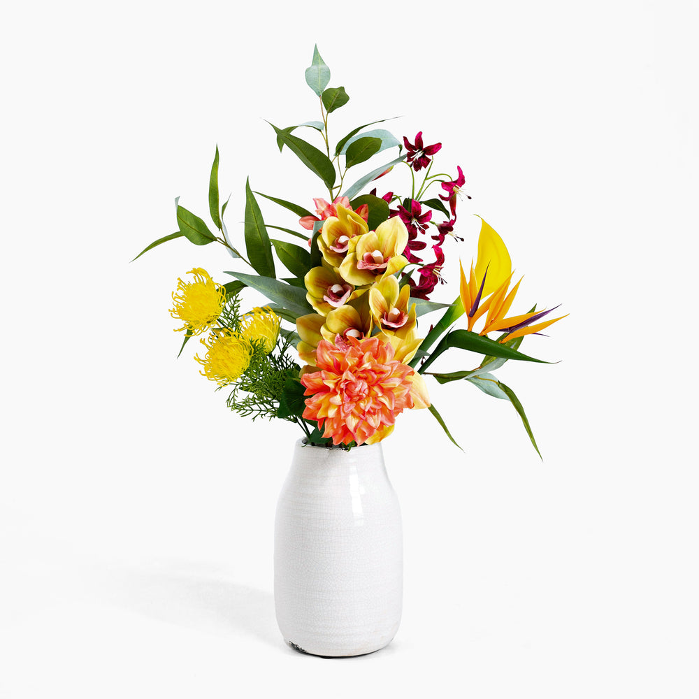 Colorful flower arrangement in a white vase on a white background