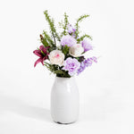 Floral arrangement in a white vase on a white background