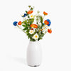 White vase with colorful flowers on a white background
