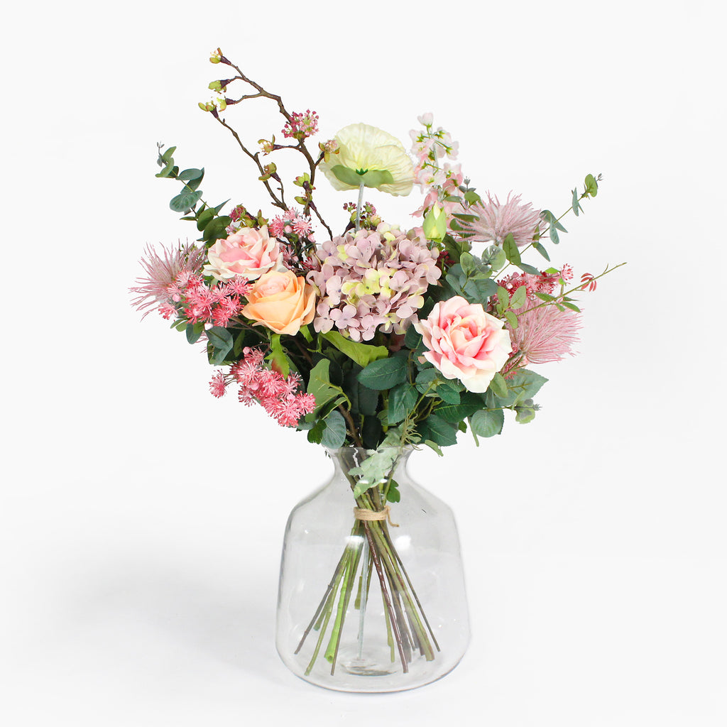 Bouquet of flowers in a clear glass vase on a white background