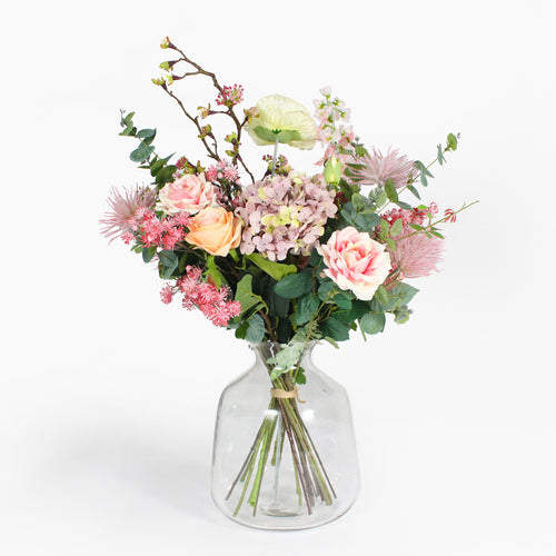Bouquet of flowers in a clear glass vase on a white background