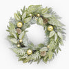 Decorative wreath with green leaves, gold ornaments, and pinecones on a white background