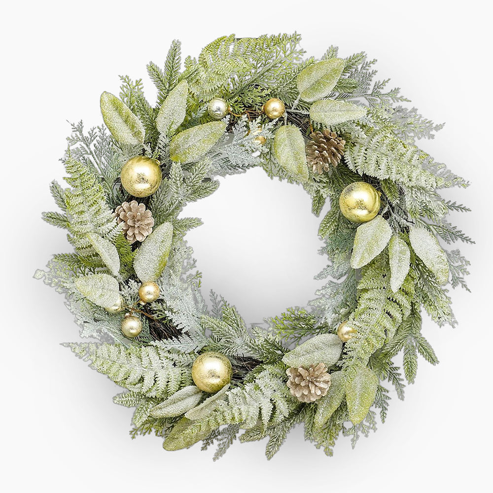 Decorative wreath with green leaves, gold ornaments, and pinecones on a white background