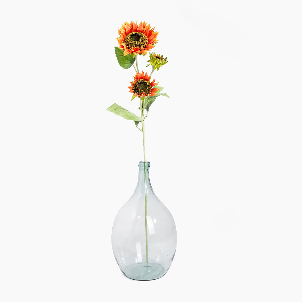 Clear glass bottle with sunflowers on a white background