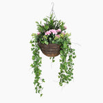 Hanging basket with greenery and pink flowers on a white background