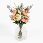 Bouquet of flowers in a clear glass vase on a white background