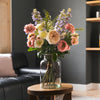 Bouquet of flowers in a vase on a wooden table in a living room.