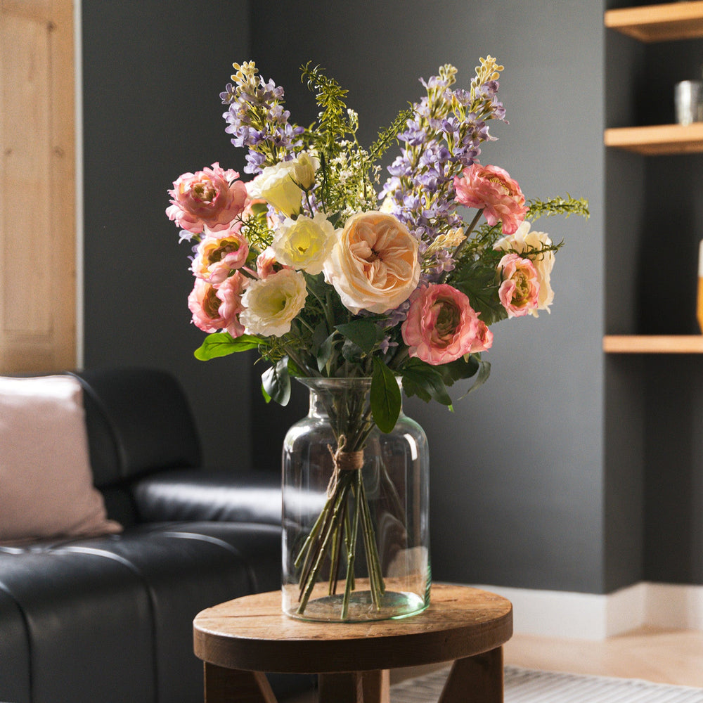 Bouquet of flowers in a vase on a wooden table in a living room.
