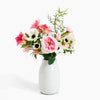 Floral arrangement in a white vase on a white background
