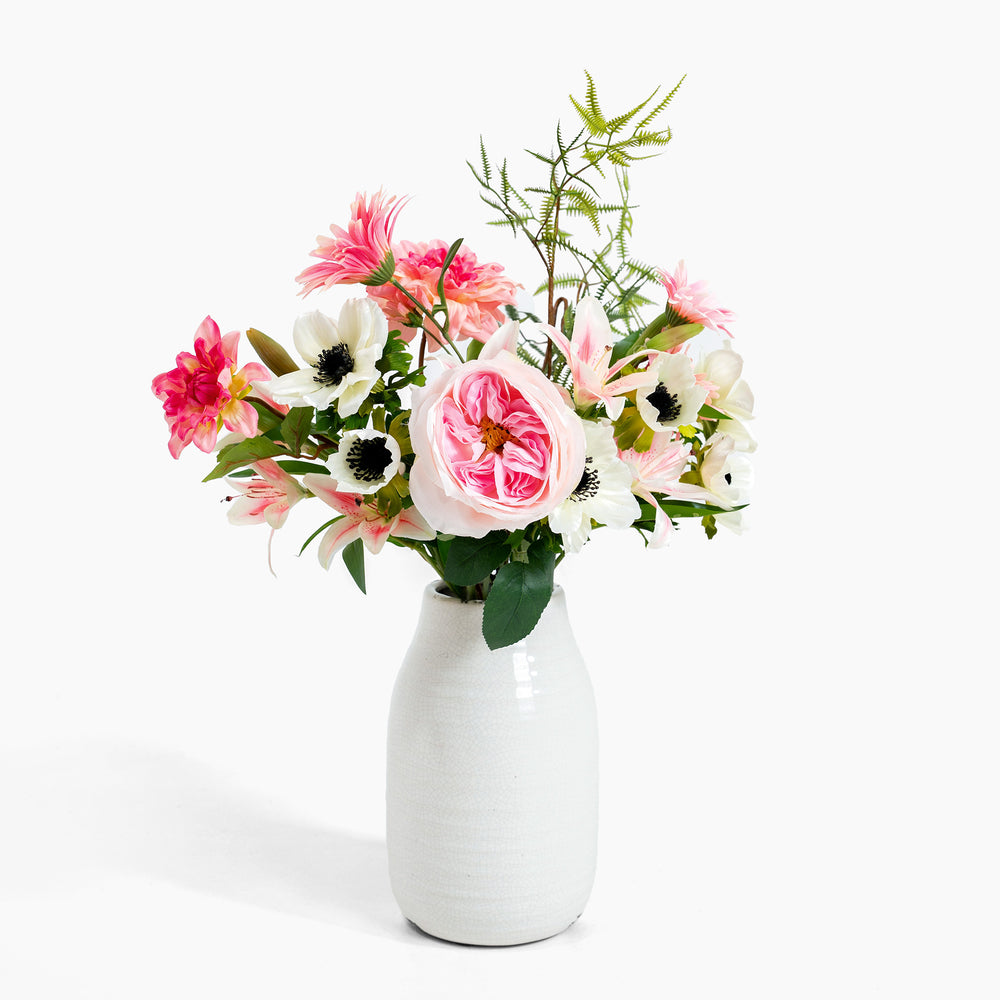 Floral arrangement in a white vase on a white background