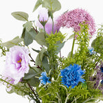 Assorted artificial flowers including pink, blue, and green on a white background