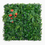 Artificial green wall with various plants and red flowers on a white background