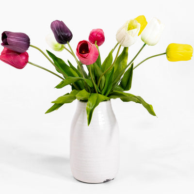 Colorful tulips in a white vase on a white background