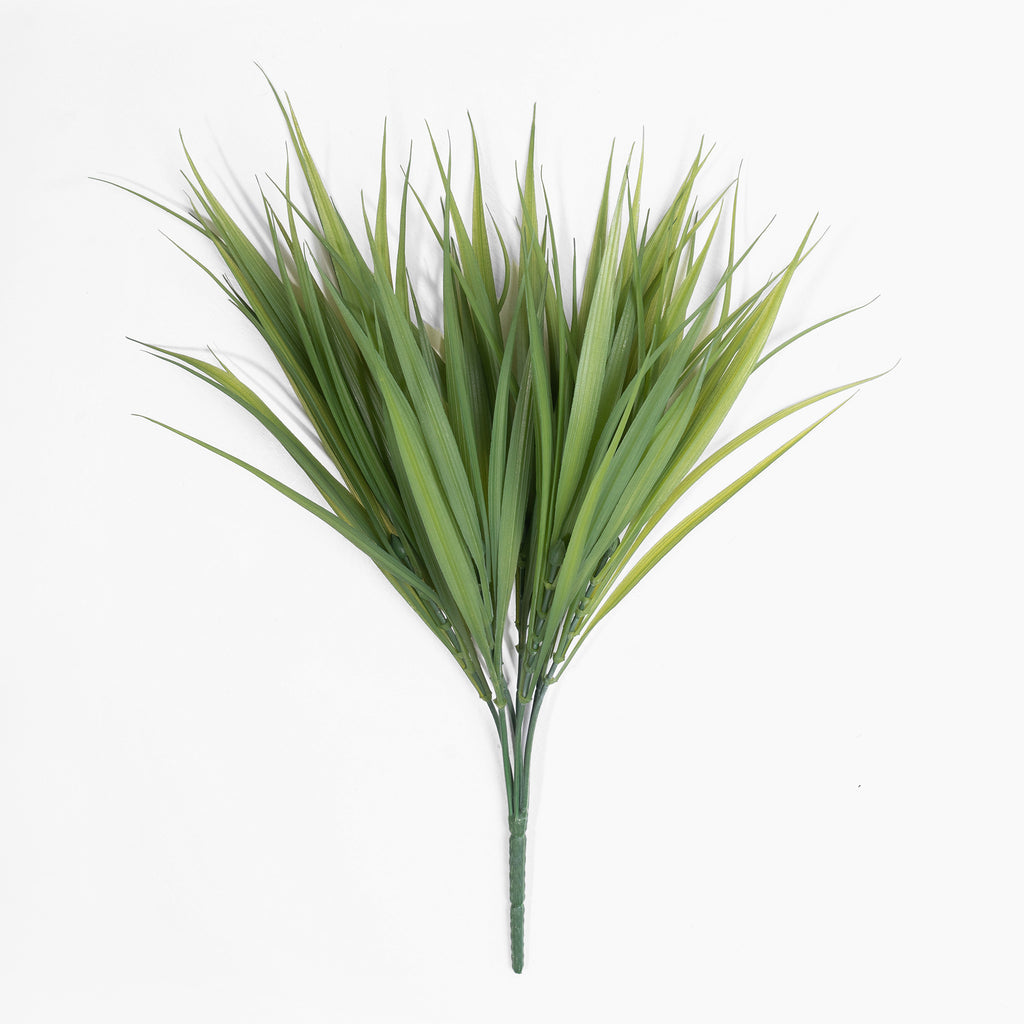 Artificial green palm leaf branch on a white background