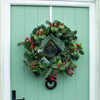 Artificial winter berry wreath on green front door
