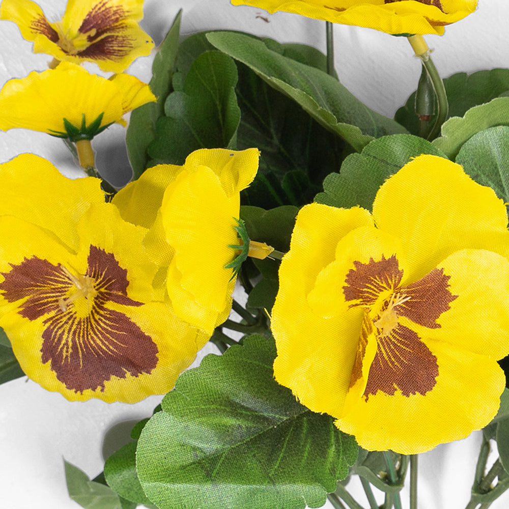 Artificial yellow pansy flowers on white background