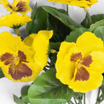 Artificial yellow pansy flowers on white background