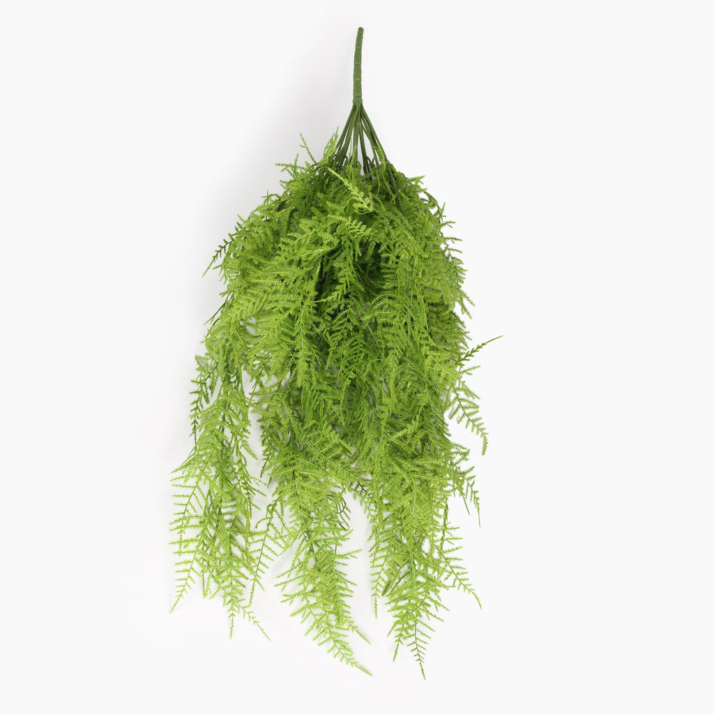 An artificial green fern bush hanging from a single spike, shown against a plain white background.