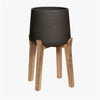Black planter with wooden legs on a white background