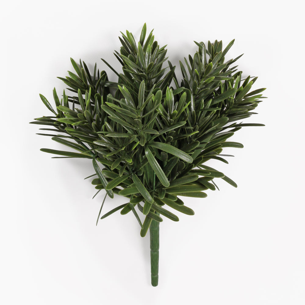 An artificial green foliage bouquet stem with dense, needle-like leaves, isolated on a clean white background.
