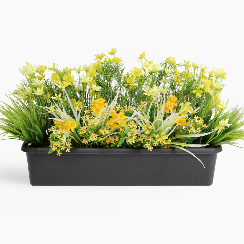 Artificial greenery with yellow flowers in a black container on a white background