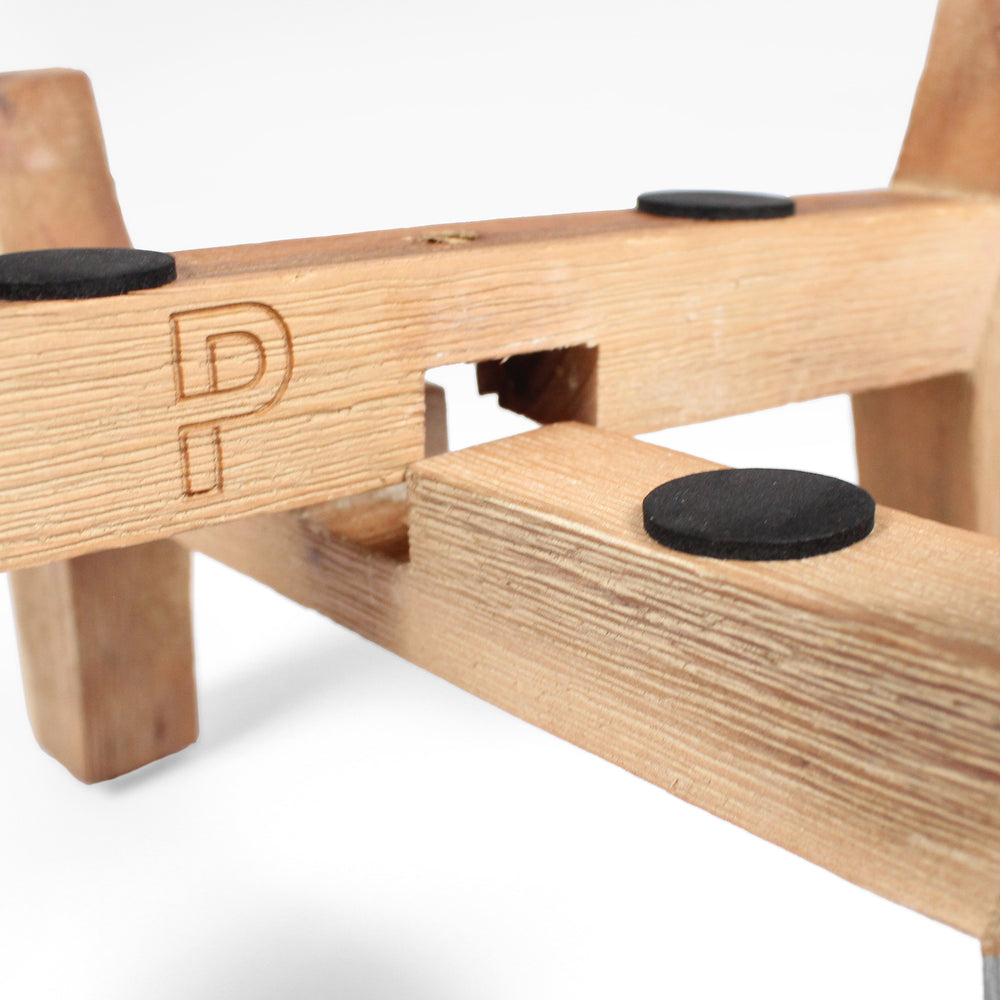 Wooden toy with black circular pieces on a white background