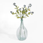 Clear glass vase with greenery on a white background
