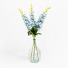 Clear glass vase with blue flowers on a white background