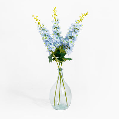 Clear glass vase with blue flowers on a white background