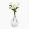 Clear glass vase with white flowers on a white background