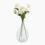 Clear glass vase with white flowers on a white background