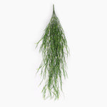 A hanging green artificial plant stem with long, wispy, needle-like leaves, shown against a plain white background.