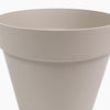 A close-up of a matte grey plastic planter pot showing the rim and side profile against a white background. 