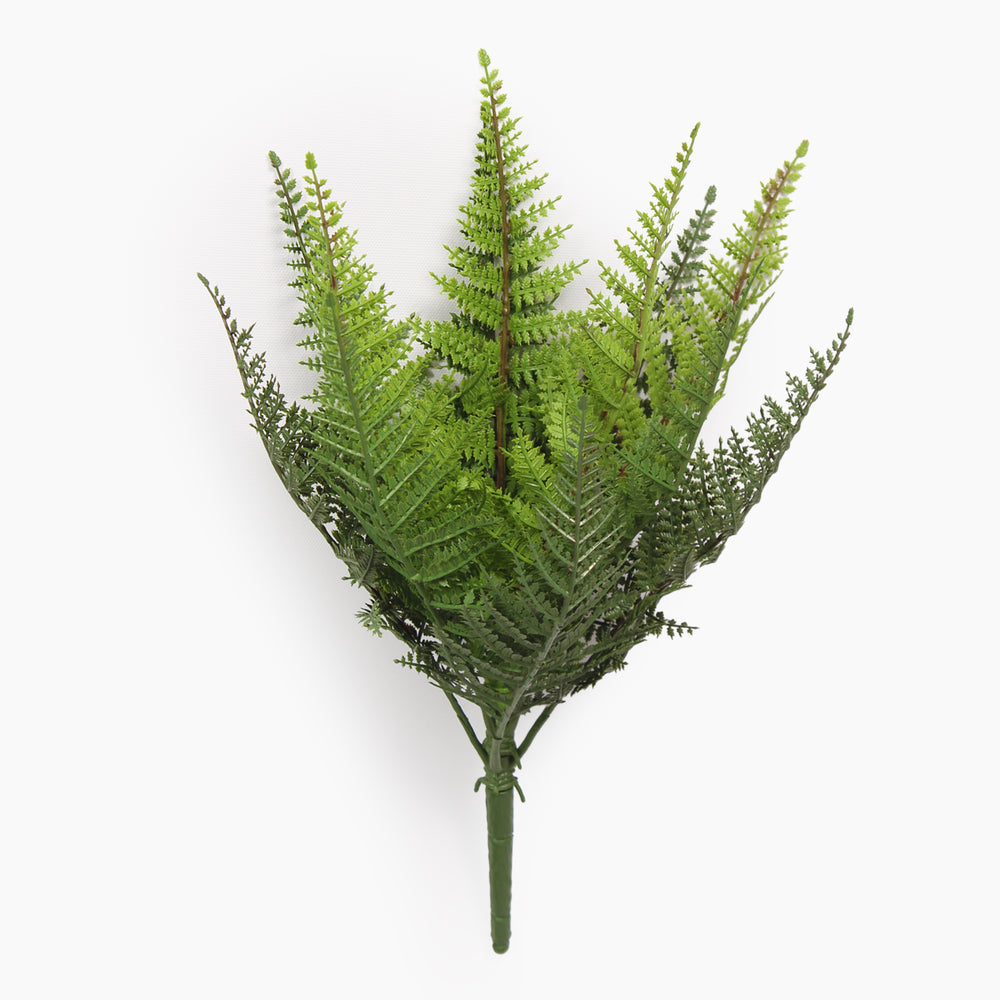 Artificial fern plant on a spike from the side on a white background