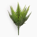 Artificial fern plant on a spike from the side on a white background