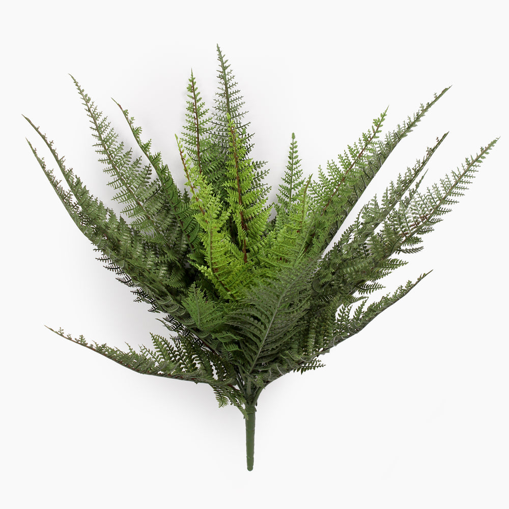 Artificial fern plant on a spike from the side on a white background